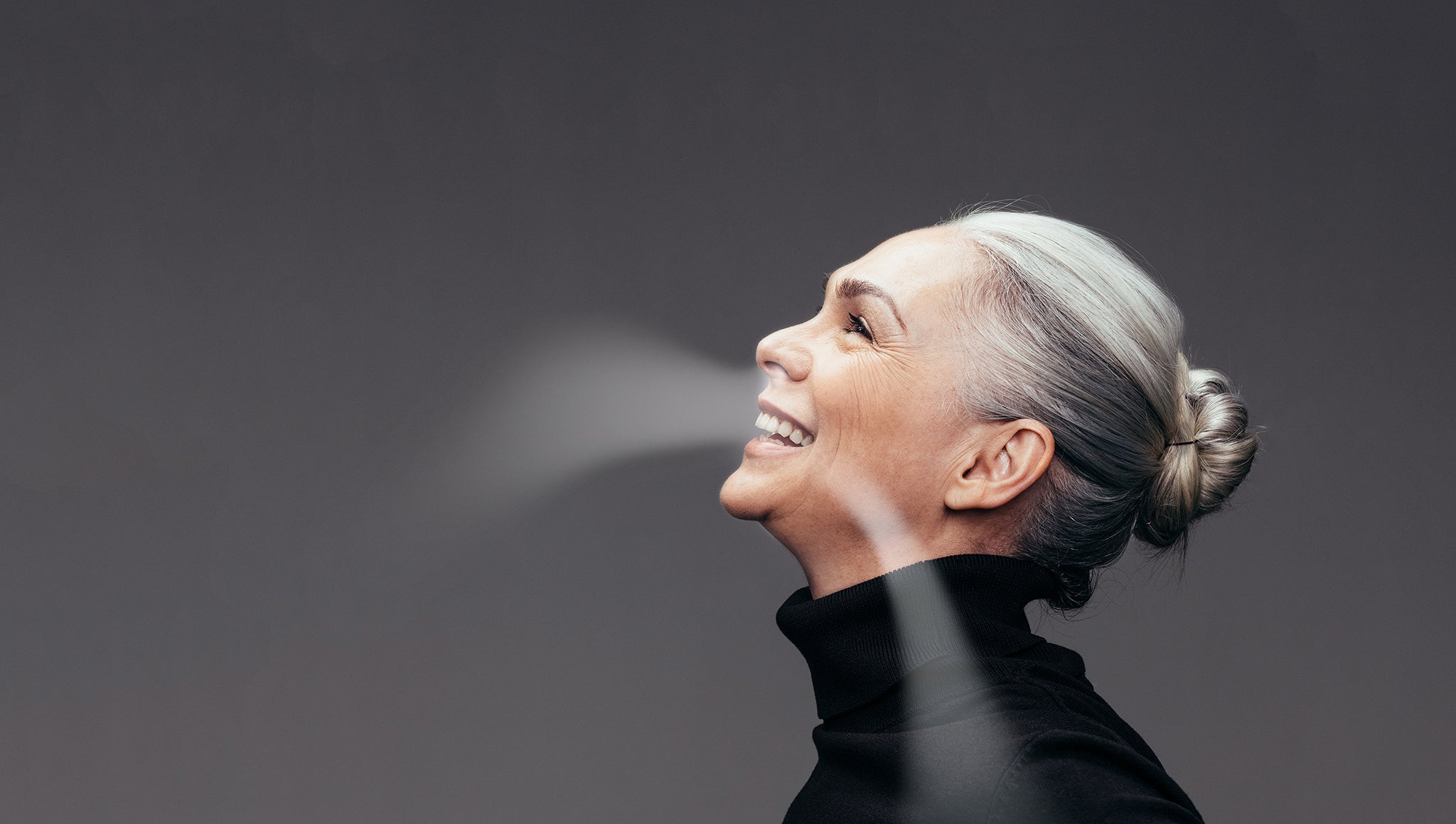 A woman smiling and breathing fresh air