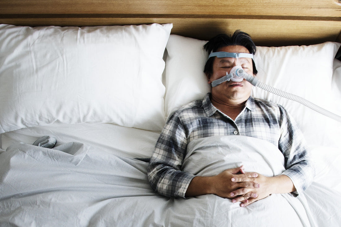 Henkilö nukkuu CPAP-maski kasvoillaan