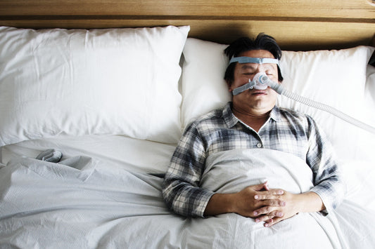 Henkilö nukkuu CPAP-maski kasvoillaan