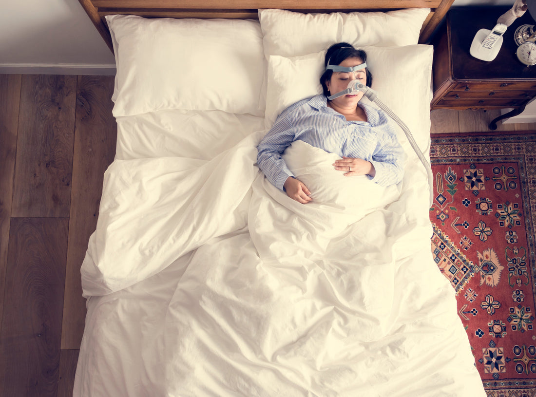 Nainen nukkumassa CPAP-laitteen kanssa