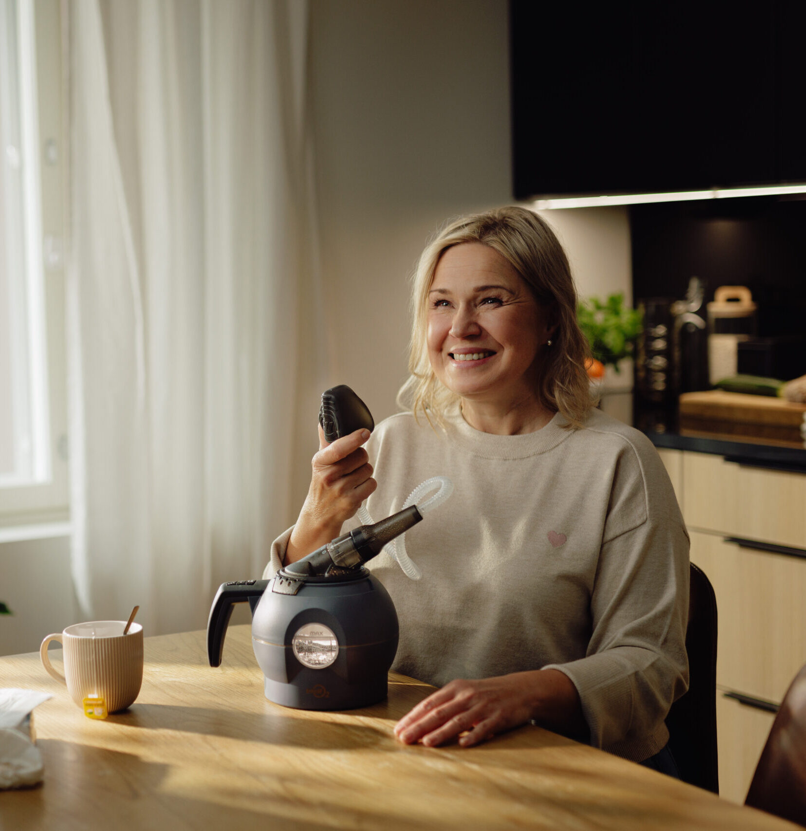 Nainen hymyilee WellO2-laitteen äärellä